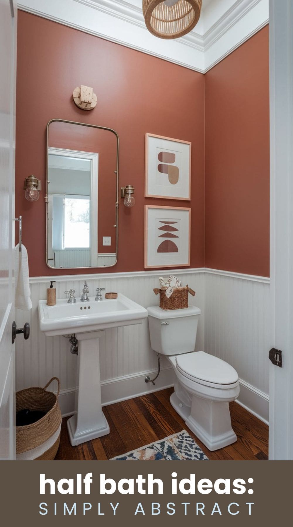 A stylish half bathroom with brown walls, white fixtures, and a wicker light fixture. There are abstract art pieces on the wall, a white pedestal sink, a toilet, and a woven basket. Text overlay reads half bath ideas: simply abstract.