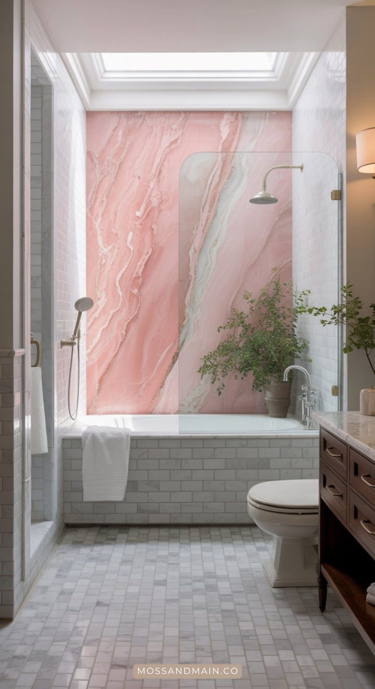 A stylish bathroom with white tiles, a glass shower enclosure, a large pink marble accent wall, and a skylight. Incorporating Pink bathroom ideas, it features a potted green plant, wooden vanity, mosaic tile floors, and a towel by the shower.
